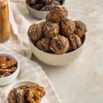 pecan pie truffles in a white bowl with dates and pecans in a bowl nearby